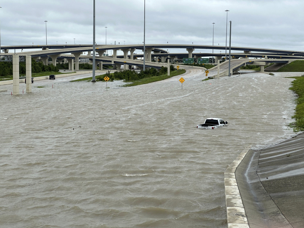 A vehicle is stranded on a flooded highway in Houston.