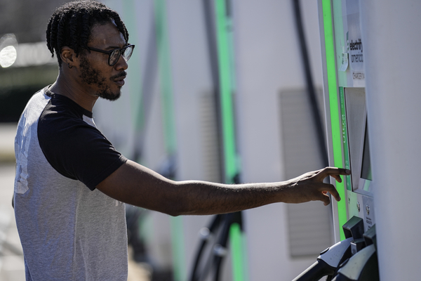 A man uses an electric vehicle charger in Kennesaw, Georgia, on Feb. 2, 2024.