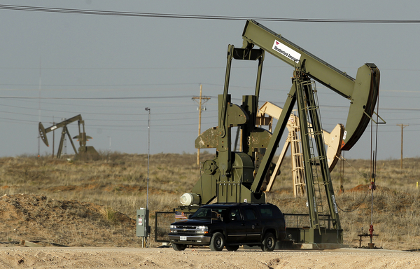 Oil pump jacks in a grass field on federal lands in Maljamar, New Mexico.