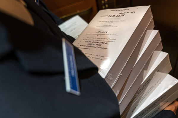 A page holds copies of the Inflation Reduction Act inside an elevator at the Capitol.