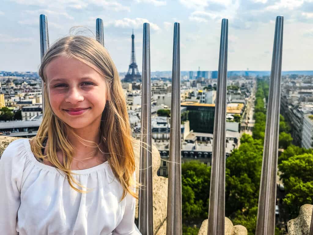 savannah standing in front of guard rails with views of paris