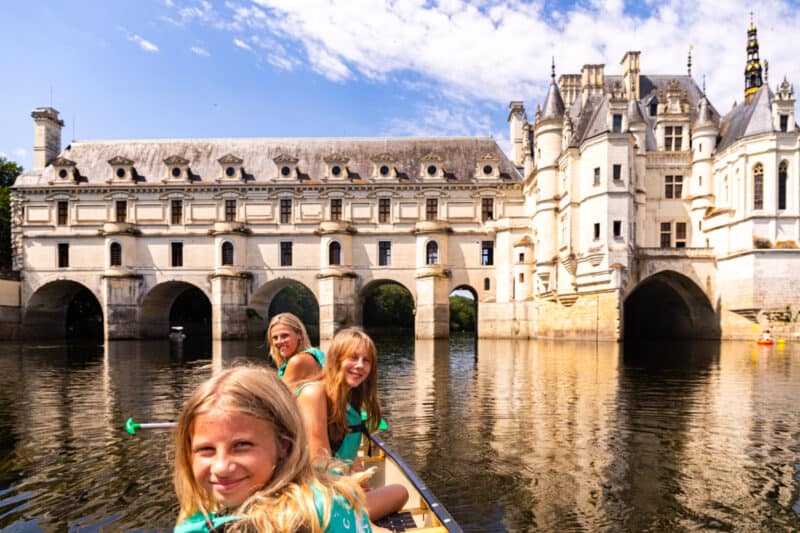 caz and girls smiling in front of Château de Chenonceau in canoe