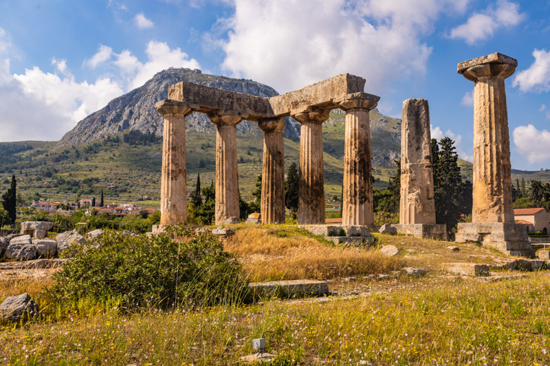 columns of temple of apollo ancient corinth in front of acropolos