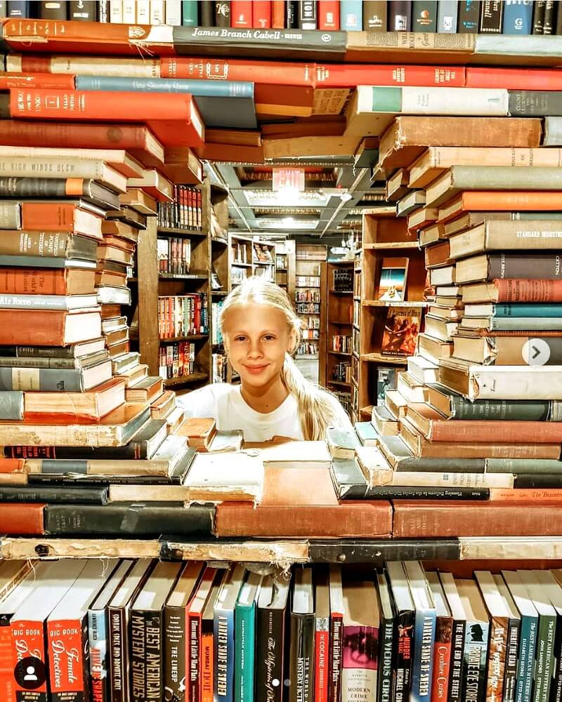 kalyra with her face in a window of books