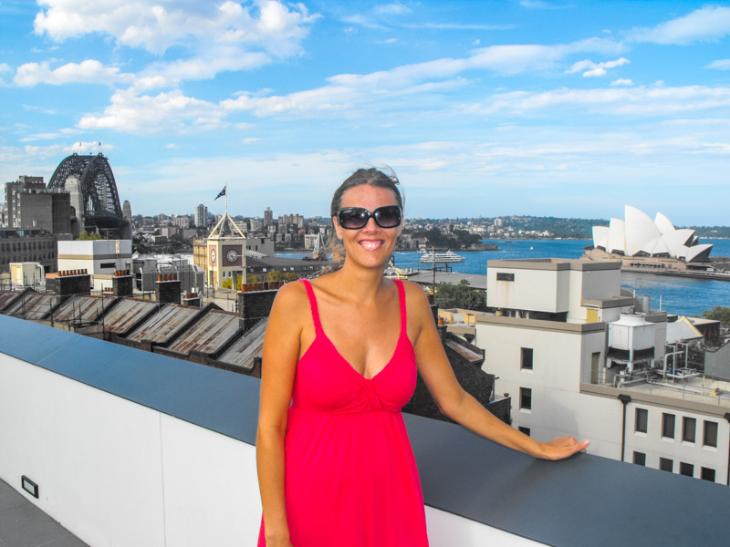 woman standing with views of opera house and harbour bridge in sydney
